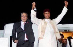 FILE - In this Thursday, Aug. 20, 2009 file photo, Libyan Abdel Baset al-Megrahi, who was found guilty of the 1988 Lockerbie bombing, left, and son of the Libyan leader Seif al-Islam Gadhafi, right, gesture on his arrival at an airport in Tripoli, Libya. Scottish prosecutors said Thursday, Oct. 15, 2015 they have identified two Libyans as suspects in the 1988 bombing of a passenger jet over the town of Lockerbie, and want to interview them in Tripoli. Scotlands Crown office said that Lord Advocate Frank Mulholland and U.S. Attorney General Loretta Lynch had agreed that there is a proper basis in law in Scotland and the United States to entitle Scottish and U.S. investigators to treat two Libyans as suspects in the continuing investigation into the bombing of flight Pan Am 103. The unnamed Libyans are suspected of involvement with Abdel Baset al-Megrahi, the only person convicted in the attack. (AP Photo)