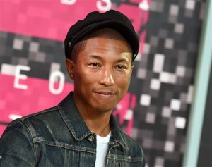 FILE - In this Aug. 30, 2015 file photo, Pharrell Williams arrives at the MTV Video Music Awards at the Microsoft Theater in Los Angeles. Pharrell has partnered with FirstBook, a nonprofit literacy organization, to donate up to 50,000 books to children in low-income families. Pharrells publisher, Penguin Young Readers, announced Tuesday, Sept. 29, that the Twitter hashtag #readHappy had been established for fans to post thoughts or images on why reading makes them Happy. Every post shared elsewhere on social media will lead to a donation. Pharrells picture book Happy, based on his hit song, comes out next week.(Photo by Jordan Strauss/Invision/AP, File)