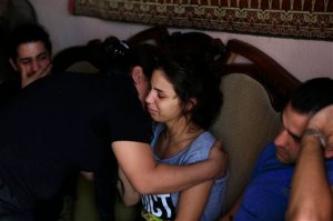 Relatives of the Safwan family mourn at the family house in Beirut's southern suburb of Ouzai, Lebanon, Thursday, Oct. 15, 2015 after a rubber boat carrying a family of 12 of their relatives to European shores sunk, drowning five while four are still missing. The Lebanese family tragedy highlights how the flood of refugees is encouraging more disenchanted around the region to take the journey to Europe, expected to get riskier in winter. (AP Photo/Hassan Ammar)