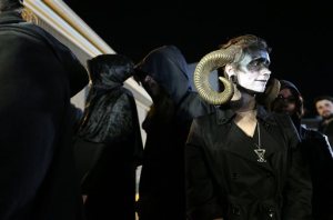 Satanic Temple of Seattle member with the name of Dice, wears horns as their group addresses the media gathered outside the gates of Bremerton Memorial Stadium during the football game on Thursday, Oct. 29, 2015. (Meegan M, Reid/Kitsap Sun via AP)