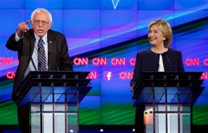 Sen. Bernie Sanders, of Vermont, left, speaks as Hillary Rodham Clinton looks on during the CNN Democratic presidential debate Tuesday, Oct. 13, 2015, in Las Vegas. (AP Photo/John Locher)