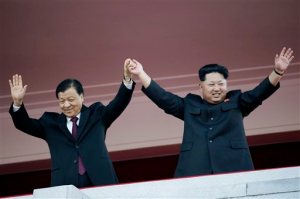 FILE - In this Saturday, Oct. 10, 2015 file photo, North Korean leader Kim Jong Un, right, waves his hands with Chinese official Liu Yunshan during a military parade to mark the 70th anniversary of the North's ruling party and trumpet Kim's third-generation leadership in Pyongyang, North Korea. The two men raised their clasped hands above their heads like a pair of victorious athletes, as international media and tens of thousands of North Koreans looked on. The gesture during a high-profile celebration in Pyongyang seemed designed to scotch appearances that their countries have been drifting apart. (AP Photo/Wong Maye-E, File)