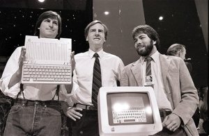 FILE - In this April 24, 1984 file photo, Steve Jobs, left, chairman of Apple Computers, John Sculley, center, president and CEO, and Steve Wozniak, co-founder of Apple, unveil the new Apple IIc computer in San Francisco. Steve Jobs, released Friday, Oct. 9, 2015, is the latest movie to examine a charismatic visionary who mesmerized the masses with his trendsetting gadgets while alienating his subordinates and friends with an almost-inhumane cruel streak. The story is told through Jobs interactions with six central figures in his life: his former marketing chief, Joanna Hoffman; his former girlfriend Chrisann Brennan; Apple co-founder and friend Wozniak; former Apple engineer Andy Hertzfeld; former Apple CEO Sculley; and Lisa, the daughter that Jobs refused to acknowledge for many years. (AP Photo/Sal Veder, File)