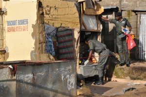 Police collect items near the site of a bomb explosion in Nyanya outskirt of Abuja, Nigeria, Saturday, Oct. 3, 2015. Multiple bombs detonated in two locations killing at least 15 people, the National Emergency Management Agency said Saturday, although no group has claimed responsibility the attack has attributes of others by Boko Haram, the home-grown Islamic extremist group.(AP Photo/Gbenga Olamikan)