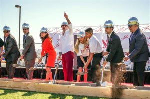In this photo provided by Pitbull, Rapper Pitbull, fourth from left, gestures during a groundbreaking ceremony for SLAM!, the school whose name stands for Sports Leadership and Management Academy, on Friday, Oct. 2, 2015, in Henderson, Nev. The school that ties sports themes to its curriculum for students seeking careers in sports medicine, marketing, business and management is expected to open in time for the 2016 school year for students in grades six through nine. Pitbull opened his first SLAM! School in Miami in 2013. (Greg Watermann for Pitbull via AP )