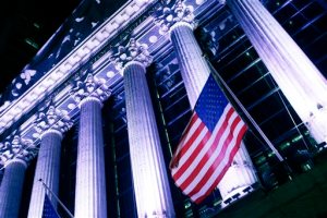 In this Wednesday, Oct. 8, 2014, photo, an American flag flies in front of the New York Stock Exchange. Global stock markets rose Wednesday, Oct. 7, 2015, taking in stride the IMF's lower global growth forecast, as oil prices extended a rebound. (AP Photo/Mark Lennihan)