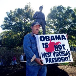 James Bennett holds a sign at a rally for coal industry jobs on Wednesday, Oct. 21, 2015, next to the Coal Miner's Statue at the state Capitol complex in Charleston, W.V. The rally coincided with a day trip to Charleston from President Barack Obama to talk about drug abuse. Speakers at the rally criticized Obama's proposed environmental rules that would limit carbon emissions from coal-fired power plants. (AP Photo/John Raby)