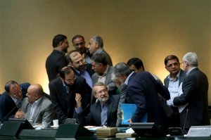 In this photo taken on Sunday, Oct. 11, 2015, Iran's parliament speaker Ali Larijani, center, speaks with lawmakers in an open session of parliament while discussing a bill on Iran's nuclear deal with world powers, in Tehran, Iran. Iran's parliament voted Tuesday to support implementing a landmark nuclear deal struck with world powers despite hard-line attempts to derail the bill, suggesting the historic accord will be carried out. (AP Photo/Ebrahim Noroozi)