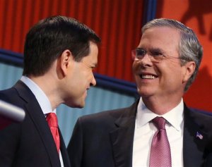 FILE - In this Aug. 6, 2015, file photo, Republican presidential candidates Marco Rubio, left, and Jeb Bush talk during a break during the first Republican presidential debate at the Quicken Loans Arena in Cleveland. Bush collected $13.4 million in recent months for his White House campaign, while competitor Rubio ended September with more available cash in the bank despite having raised less than half as much.  (AP Photo/Andrew Harnik)