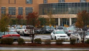 Cars sit in the parking lot Tuesday, Oct. 27, 2015, in Columbia S.C. The Justice Department opened a civil rights investigation Tuesday after Senior Deputy Ben Fields flipped a student backward in her desk and tossed her across the floor for refusing to leave her math class. Federal help was sought by Richland County Sheriff Leon Lott, who called what happened at Spring Valley High School in Columbia, "very disturbing" and placed on Fields leave. (AP Photo/Alex Sanz)