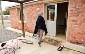 In this Oct. 7, 2015 photo, Syrian refugee Nada Alshebli, 19, enters her family's home in Juan Lacaze, Uruguay. Uruguay's attempt to help the plight of Syrians fleeing their nation's civil war by sheltering 42 refugees, a largely symbolic gesture given that over 4 million Syrians have fled since civil war broke out in 2011, appears to be backfiring. Many refugee families complain that life in Uruguay is expensive and authorities aren't doing enough to support them. Nada, one of 15 children, sells Arab food downtown and recently worked in an assisted living facility, but earned just $68 in a little under a month. (AP Photo/Matilde Campodonico)