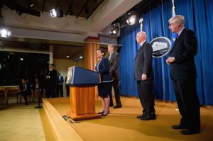 Attorney General Loretta Lynch, left, accompanied by, from left, Education Secretary Arne Duncan, U.S. Attorney of the Western District of Pennsylvania David Hickton and Iowa Attorney General Tom Miller, speaks at a news conference at the Justice Department in Washington, Monday, Nov. 16, 2015, to announce a major federal and state civil litigation settlement concerning Educational Management Corp., a Pittsburgh-based company that runs for-profit trade schools. (AP Photo/Andrew Harnik)