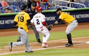 Cardenales' Elvis Escobar (2) is caught in a rundown by Aguilas third baseman Jonathan Villar as Richard Rodriguez (79) trails during the fifth inning during the championship baseball game pf Serie de las Americas at Marlins Park in Miami, Sunday, Nov. 22, 2015. (AP Photo/Joe Skipper)