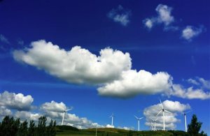 In this July 30, 2015 photo, wind turbines are built on a hill along a highway near Jiamusi, in northeastern China's Heilongjiang province. Heading into this months Paris climate meeting, China, the worlds biggest source of climate-changing gases has yet to accept binding limits. But it has invested in solar, wind and hydro power to clean up its smog-choked cities and curb surging demand for imported oil and gas. (AP Photo/Andy Wong)