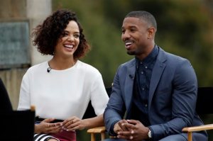 FILE - In this Friday, Nov. 6, 2015 file photo, Michael B. Jordan, right, and Tessa Thompson laugh during an interview while promoting their film "Creed" outside the Philadelphia Museum of Art, in Philadelphia. While characters wearing eyeglasses - real or as props - are commonplace in movies and TV, hearing aids are seldom seen on the screen - especially on leading ladies. Thats why actress Thompson was so honored to portray a strong woman character who wears the devices in the upcoming Rocky franchise spinoff, Creed, in theaters Nov. 27. (AP Photo/Matt Slocum, File)