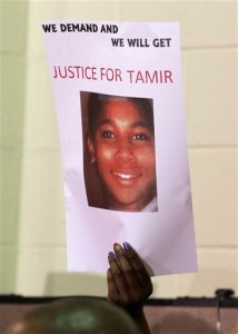 FILE- This Dec. 8, 2014 file photo shows a person holding up a sign for justice for Tamir Rice during a news conference in Cleveland. A white Cleveland police officer had no choice but to fatally shoot a 12-year-old black boy carrying a pellet gun, an expert on police use of force said in a report released publicly Thursday, Nov. 12, 2015, by the Cuyahoga County Prosecutor's Office. Retired Florida police officer W. Ken Katsaris is the third expert who has concluded that patrolman Timothy Loehmann was justified in shooting Tamir Rice outside a Cleveland recreation center Nov. 22, 2014.  (AP Photo/Tony Dejak, File)