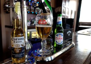 FILE - In this Tuesday, Oct. 13, 2015, file photo, drinks sit on the bar in a pub in London. The world's two biggest beer makers will join forces to create a company that produces almost a third of the world's beer, as Budweiser maker AB InBev announced Wednesday, Nov. 11, 2015, a final agreement to buy SABMiller for 71 billion pounds ($107 billion). But in the U.S., the deal will not bring arch rivals Budweiser and Miller under the same roof. AB InBev's brands include Budweiser, Stella Artois and Corona, while SABMiller produces Peroni and Grolsch. (AP Photo/Kirsty Wigglesworth, File)