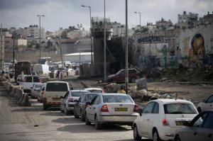 In this Tuesday, Nov. 10, 2015 photo, Palestinians wait in traffic to enter Jerusalem at Qalandia checkpoint between Jerusalem and the West Bank city of Ramallah. A pair of new mobile apps hopes to help Palestinians navigate their way around snarled traffic at Israeli checkpoints in the West Bank, offering a high-tech response to an intractable problem: constant, burdensome and often seemingly random restrictions on movement.  (AP Photo/Majdi Mohammed)