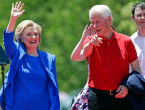 FILE - In this June 13, 2015 file photo, Democratic presidential candidate, former Secretary of State Hillary Rodham Clinton, and her husband, former President Bill Clinton, gesture to supporters on Roosevelt Island in New York. Former President Bill Clinton will headline his first rally for his wifes presidential campaign on Saturday. He plans to address supporters of Hillary Rodham Clintons second White House bid before the Iowa Democratic Party dinner in Des Moines. The gathering is an important stop for presidential candidates seeking support in the early caucus state. (AP Photo/Frank Franklin II, File)