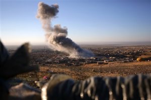 Smoke believed to be from an airstrike billows over the northern Iraqi town of Sinjar on Thursday, Nov. 12, 2015. Kurdish Iraqi fighters, backed by the U.S.-led air campaign, launched an assault Thursday aiming to retake the strategic town of Sinjar, which the Islamic State overran last year in an onslaught that caused the flight of tens of thousands of Yazidis and first prompted the U.S. to launch airstrikes against the militants. (AP Photo/Bram Janssen)
