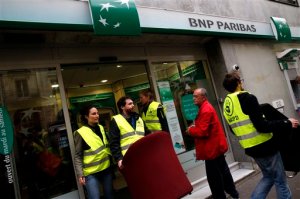 Activists from the NGO "Non violent action COP21" leave a bank after taking the chairs   as part of the "Citizen Requisition of Chairs" to protest against tax evasion, in Paris, Thursday, Nov. 12, 2015. The protest is one of many activist actions linked to the Paris climate conference, known as COP21, runs Nov. 30-Dec 11. (AP Photo/Christophe Ena)