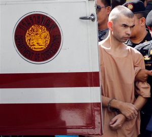 Police officers escort a suspect in the Aug. 17 blast at Erawan Shrine, Bilal Mohammad, right, on his arrival at a military court in Bangkok, Thailand, Tuesday, Nov. 24, 2015. The military court has indicted two men police say carried out the deadly August bombing at the shrine that left 20 people dead and more than 120 injured. (AP Photo/Sakchai Lalit)