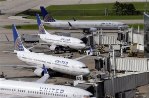 FILE - In this July 8, 2015 file photo, United Airlines planes are parked at their gates as another plane, top, taxis past them at George Bush Intercontinental Airport in Houston. U.S. airlines have ramped up an aggressive lobbying campaign that seeks nothing less than converting the government from industry regulator to business ally. The big three legacy carriers, Delta, American and United, want the Obama administration to protect them from competition from foreign airlines, arguing those rivals can undercut ticket prices thanks to government subsidies or cheaper labor. (AP Photo/David J. Phillip, File)