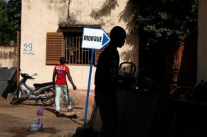 Hospital workers walk, outside the morgue of the Gabriel Toure hospital, in Bamako, Mali, Sunday, Nov. 22, 2015. The heavily armed Islamic extremists who shot up a luxury hotel in Mali's capital, killing 19 people, timed their assault for the moment when guards would be the most lax, allowing them to easily blast their way past a five-man security team before turning their weapons on terrified guests, a security guard and witnesses said Saturday.  (AP Photo/Jerome Delay)