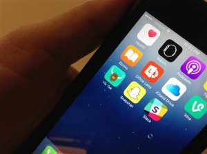 The Yik Yak app, lower, left, is seen on an iPhone in Washington, Wednesday, Nov. 11, 2015. Internet users of the Yik Yak social media gossip app popular among college students aren't nearly as anonymous as they believe: Missouri police within hours arrested a student accused of threatening violence, the latest in a string of such arrests at colleges in recent months involving threats posted online.   (AP Photo/Ronald Lizik)