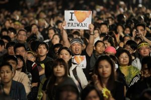 File- In this March 30, 2014 file photo, a protester displays a banner supporting Taiwan during a massive protest against China in front of the Presidential Building in Taipei, Taiwan. Taiwan struggles with its identity as it retains its official name Republic of China, along with a constitution that defines its territory as encompassing all of mainland China. But as far as communist China is concerned, Taiwan is part of its territory, and insists that the two sides eventually reunite. (AP Photo/Wally Santana, File)
