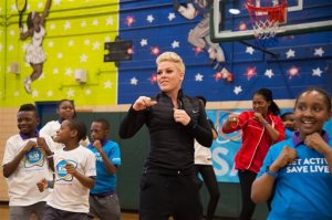 Singer Pink exercises with students from PS 242 Young Diplomats Magnet Academy at the launch of UNICEF Kid Power on Monday, Nov. 30, 2015, in New York. (Photo by Charles Sykes/Invision/AP)