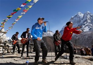 In this Sunday, Nov. 15, 2015 photo, Signmark, whose real name is Marko Vuo, in red jacket, who was born deaf, along with Olli Pekka, in blue jacket, performs with the Finnish rock band Ancara at Dingboche, a village at an altitude of 4,550 meters (14,900 feet) and a popular stop for trekkers and mountaineers heading to Everest and other peaks, Nepal. Ancara and the sign-language rapper performed in the foothills of Mount Everest over the weekend to raise funds for a music school for children with hearing disabilities. (AP Photo/Tashi Sherpa)