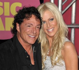 FILE - In this June 6, 2012, file photo, Neal Schon, left, and Michaele Salahi arrive at the CMT Music Awards in Nashville, Tenn. San Francisco supervisors are considering a $290,000 payout to settle a lawsuit by Schon, the guitarist of rock band Journey over his lavish 2013 wedding to the former reality television star, Salahi. A committee of the Board of Supervisors is scheduled to take up the proposed settlement Thursday, Nov. 12, 2015.  (Photo by John Shearer/Invision/AP File)
