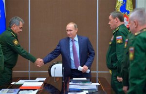 FILE In this Tuesday, Nov. 10, 2015 file photo Russian President Vladimir Putin, centre, shakes hands with Defense Minister Sergei Shoigu at a meeting with defense officials in the Bocharov Ruchei residence in the Black Sea resort of Sochi, Russia. President Vladimir Putin's spokesman said plans for a new submarine-launched nuclear torpedo shown on Kremlin-controlled television were secret and should never have been aired. NTV and Channel One showed a large document filmed over a military officer's shoulder during a meeting with Putin with drawings and details of a weapons system called Status-6. Second right is Chief of the General Staff of the Russian Armed Forces Valery Gerasimov. (Alexei Druzhinin/RIA Novosti, Kremlin Pool Photo via AP)