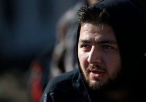 In this Monday, Nov. 16, 2015 photo, Mohamad Nouv Khanji, a Syrian doctor waits to register with the police in refugee center in the southern Serbian town of Presevo. Khanji traveled with his passport, but the EU border security agency Frontex says most migrants enter Europe with no valid documents. In a growing number of cases, they carry fake IDs as they pretend to be Syrian to improve their asylum chances. That also has raised fears of Islamic extremists entering Europe with false documents. (AP Photo/Darko Vojinovic)