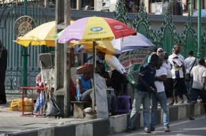 People buy MTN accessories on a street in Lagos, Nigeria Thursday, Nov. 5, 2015. Africa's biggest telecommunications company is locked in a nasty battle with one of the most powerful governments on the continent, with billions of dollars at stake. MTN Nigeria, MTN Group's subsidiary here, was fined $5.2 billion for failing to meet an August deadline to deactivate 5.2 million unregistered cellphone SIM cards. (AP Photo/Sunday Alamba)