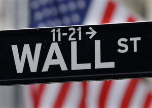 FILE - This July 9, 2015, file photo, shows a Wall Street sign near the New York Stock Exchange. Global stock markets drifted lower Thursday, Nov. 12, 2015, as investors looked past some fairly dovish remarks from the head of the European Central Bank and awaited a slew of comments from Federal Reserve officials, notably those of Fed Chair Janet Yellen. (AP Photo/Seth Wenig, File)