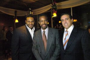 In this photo taken Dec. 1, 2005, Dr. Ben Carson, center, flanked by Dr. Al Costa, right, and then Pittsburgh Steelers running back, Jerome Bettis pose at the The Pittsburgh Carson Scholars Fund 2nd Annual Charity Auction Cocktail Event in Pittsburgh. Republican presidential contender Carson has maintained a business relationship with Costa, a close friend convicted of defrauding insurance companies and testified on his behalf, even as the candidate has called for such crimes to be punished harshly. (Andy Starnes/Pittsburgh Post-Gazette via AP)