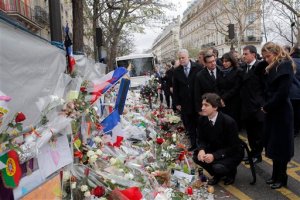 Canadian Prime Minister Justin Trudeau, center, his wife Sophie Gregoire, right, French prime minister Manuel Valls, second right,  and Paris mayor Anne Hidalgo, third right,  pay their respects to victims of the Paris attacks in front of the Bataclan concert hall, in Paris, Sunday, Nov. 29, 2015. The country remains on high alert for possible terrorist attacks after Islamic extremists killed at least 130 people in a rock concert massacre, shootings at Paris cafes and suicide bombings at the national stadium on Nov. 13. (AP Photo/Christophe Ena)