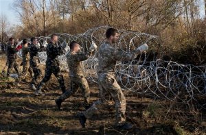 Slovenian solders erect razor wire fence in Rakovec, Slovenia, Thursday, Nov. 12, 2015. European leaders scrambled Thursday to keep their passport-free travel zone from collapsing, after Germany, Sweden and Slovenia acted on their own to tighten borders or erect fences to slow the relentless influx of people marching into Europe. (AP Photo/Darko Bandic)