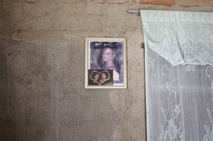 This Sept. 23, 2015 photo shows Yainis Souto's portrait when she was 15-years-old, as well as a photo of her with her then-boyfriend Jose Fuentes Lastre, inside her home in Camaguey, Cuba. Souto and Lastre broke up while they tried to maintain a long distance relationship, with Lastre in the U.S. and Souto in their childhood neighborhood of Porvenir. (AP Photo/Christine Armario)