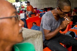 Cuban migrants sit outside the immigration office in Peñas Blancas, Costa Rica, Tuesday, Nov. 17, 2015. More than 1,000 Cuban migrants heading north to the United States tried to cross the border from Costa Rica into Nicaragua, causing tensions to soar between the neighbors as security forces sought to turn them back. Nicaragua's government responded furiously on Sunday with a statement saying that Costa Rica "had deliberately and irresponsibly thrown, and continues to throw" the Cuban migrants into its territory, violating its national sovereignty. (AP Photo/Esteban Felix)