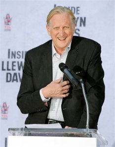 FILE - In this Nov. 14, 2013 file photo, T-Bone Burnett, executive music producer of the film "Inside Llewyn Davis," addresses the crowd during a hand and footprint ceremony for cast member John Goodman in Los Angeles. Burnett, known for keeping alive forms of American roots music, replaces the previously announced songwriting team of Alan Menken and Glenn Slater, who were unable to continue on Happy Trails due to a scheduling conflict. (Photo by Chris Pizzello/Invision/AP, File)