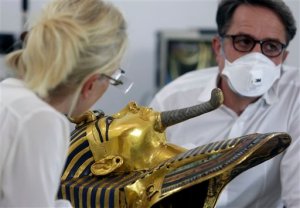 German restorers Christian Eckmann, right, and Katja Broschat examine the famed golden mask of King Tutankhamun as an Egyptian-German team begins restoration work over a year after the beard was accidentally broken off and hastily glued back with epoxy, at the Egyptian Museum in Cairo, Egypt, Tuesday, Oct. 20, 2015. The 3,300-year-old burial pharaonic mask was discovered in Tutankhamun's tomb along with other artifacts by British archeologists in 1922, sparking worldwide interest in archaeology and ancient Egypt. (AP Photo/Amr Nabil)