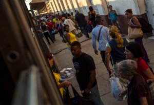 In this March 23, 2015 photo, a street vendor sells homemade sweets to travelers at a train station in the Ciego de Avila province in Cuba. At their peak, Cuban trains featured dining cars and other high-end services. Today, refreshment comes from the vendors who board at many stations offering cold sandwiches and soft drinks.  (AP Photo/Ramon Espinosa)