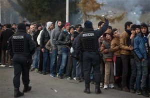 In this Thursday, Nov. 5, 2015, photo, migrants wait for food and water distribution as they wait to be allowed to cross to Austria, in Sentilj, Slovenia. With the European Union estimating that three million more migrants will arrive in Europe over the next year, the patience of Slovenians, traditionally known for tolerance, is wearing thin. Their government announced Tuesday, Nov. 10, 2015, that a fence will be put up to control the flow, although not completely to stop it. (AP Photo/Darko Bandic)
