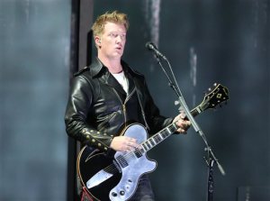 FILE - In this Jan. 26, 2014 file photo, Joshua Homme, of Queens of the Stone Age, performs at the 56th annual Grammy Awards in Los Angeles. Homme, also a member of Eagles of Death Metal, was scheduled to perform, Friday, Nov. 13, 2015, at the Bataclan venue in Paris where patrons were taken hostage. The band says they are home safe after the Paris attacks, but they are horrified and still trying to come to terms with what happened in France. The band released a new album last month and was on an European tour when the attacks occurred. They said all shows are on hold until further notice. (Photo by Matt Sayles/Invision/AP, File)