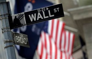 FILE - This Oct. 2, 2014 file photo shows a Wall Street sign adjacent to the New York Stock Exchange, in New York.  European shares shed earlier gains Thursday, Dec. 3, 2015 after the European Central Bank failed to cut a key interest rate as much as many in the markets had expected. (AP Photo/Richard Drew, File)