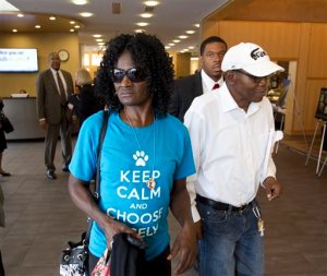 FILE - In this May 5, 2015 file photo, Freddie's Gray mother, Gloria Darden, left, accompanied by Richard Shipley, arrives at the University of Baltimore to meet with Attorney General Loretta Lynch in Baltimore, Md. Following protests online, CNN removed a description of Baltimore's Freddie Gray as "the son of an illiterate heroin addict" in a story posted about the first police officer about to go on trial for Gray's death last spring while in police custody. The print story, originally posted Monday, Nov. 30, 2015, was changed that evening to remove the description of Gray's mother. (AP Photo/Jose Luis Magana, Pool, File)