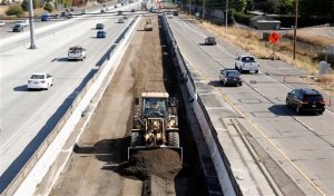 FILE - In this Oct. 15, 2015 file photo, vehicles pass a highway construction site on eastbound Interstate 80 in Sacramento, Calif. The House and Senate have reached agreement on a 5-year, $281 billion transportation bill that would increase spending to address the nation's aging and congested highways and transit systems _ a legislative feat that lawmakers and President Barack Obama have struggled throughout his entire administration to achieve. (AP Photo/Rich Pedroncelli, File)